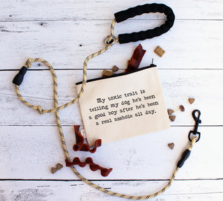 The good boy dog zipper pouch shown styled with a leash and dog treats.