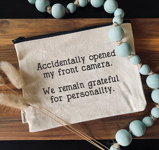 The front camera zipper pouch shown styled with a string of beads.
