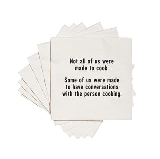 White cocktail napkin with the text 'Not all of us were made to cook. Some of us were made to have conversations with the person cooking.' printed in black ink.