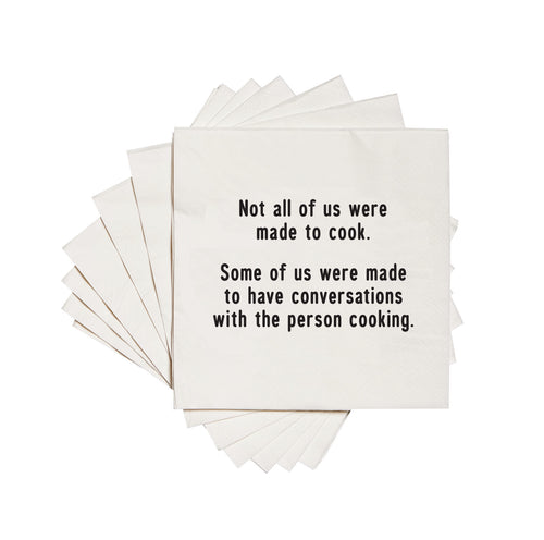 White cocktail napkin with the text 'Not all of us were made to cook. Some of us were made to have conversations with the person cooking.' printed in black ink.