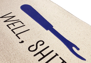 A close up view of the canvas zip pouch with the "Well, shit" seam ripper design.