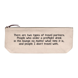 Cotton canvas zip pouch printed in black text reading "There are two types of travel partners. People who order a preflight drink in the lounge no matter what time it is, and people I don't travel with."