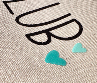 Close-up of the "Book Club" design with hearts in teal and mint puff ink.