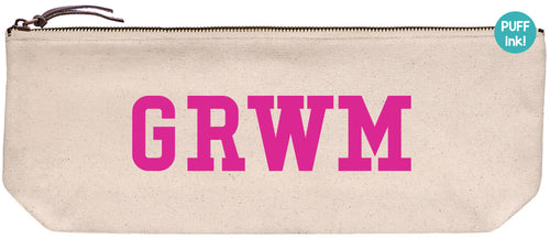 Beige zipper pouch with 'GRWM' text printed in pink PUFFY ink.