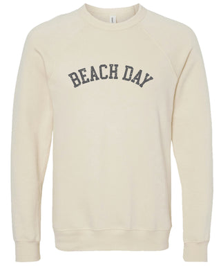 Cream colored sweatshirt with 'BEACH DAY' text printed in gray ink. 
