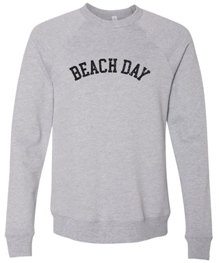 Gray colored sweatshirt with 'BEACH DAY' text printed in black ink. 