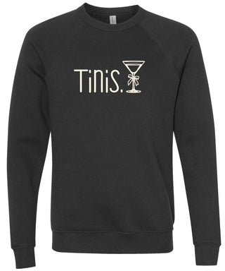 Black sweatshirt with 'Tinis.' text and martini glass graphic printed in cream ink.