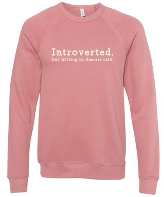 Dusty rose sweatshirt with text 'Introverted, but willing to discuss cats' printed in cream ink.