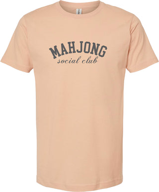 Peach t-shirt with 'MAHJONG social club' printed in gray ink.