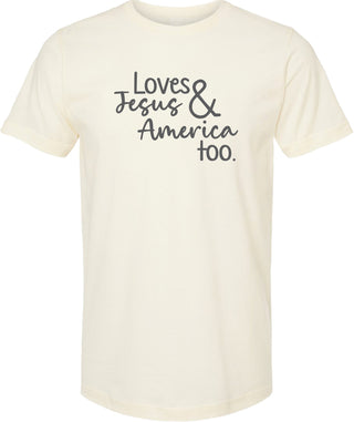 Cream t-shirt with text 'Loves Jesus & America too.' printed in gray ink.