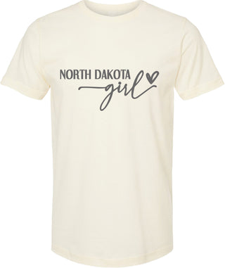 Cream t-shirt with 'North Dakota Girl' text and heart graphic on a white background
