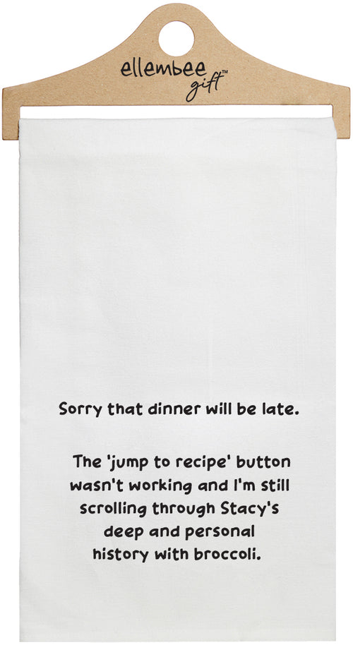 White towel with printed text 'Sorry that dinner will be late.  The 'jump to recipe' button wasn't working and I'm still scrolling through Becca's deep and personal history with broccoli.' printed in black ink.