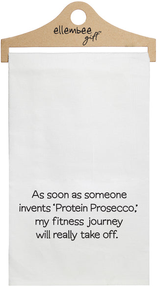 White towel with printed text 'As soon as someone invents 'Protein Prosecco', my fitness journey will really take off..' printed in black ink.