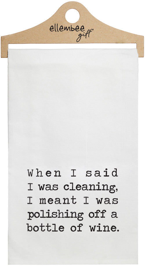White towel with the text 'When I said I was cleaning, I mean't I was polishing off a bottle of wine.' printed in black ink.