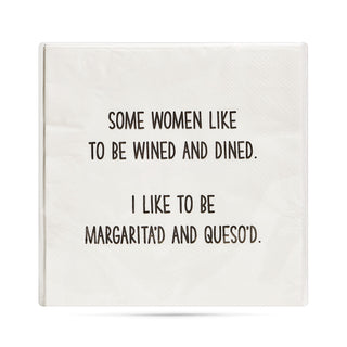White 3-ply cocktail napkin printed in black with "Some women like to be wined and dined. I like to be margarita'd and queso'd."