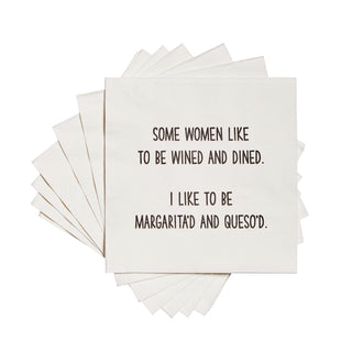 Stack of white 3-ply cocktail napkin printed in black with "Some women like to be wined and dined. I like to be margarita'd and queso'd."