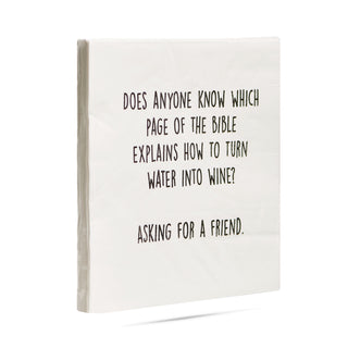 A side view of a pack of white 3-ply cocktail napkins printed in black with "Does anyone know which page of the Bible explains how to turn water into wine? Asking for a friend."