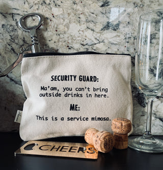 A lifestyle shot of the service mimosa zipper pouch shown with champagne corks and a champagne glass