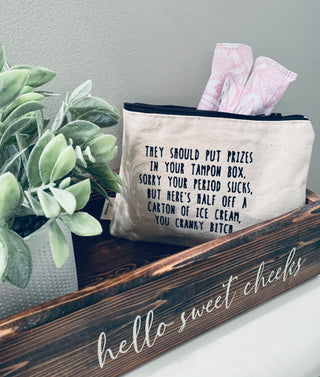 Lifestyle shot of the "tampon box prizes" canvas zipper pouch.