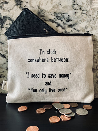 Lifestyle shot of the "save money or YOLO" canvas zipper pouch.