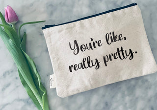 Lifestyle shot of the "you're like really pretty" canvas makeup bag.